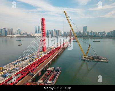 Aerial view of cranes and construction equipment are working to dismantle an old cable stayed bridge. Stock Photo