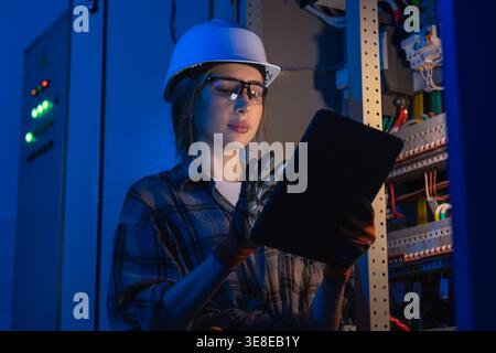 Electrical specialist inspecting power system with tablet device. Engineering control. Stock Photo