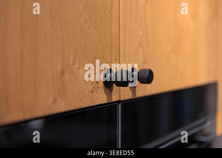 Modern kitchen cabinet handles on wooden fronts close up. Minimalist kitchen design. Stock Photo