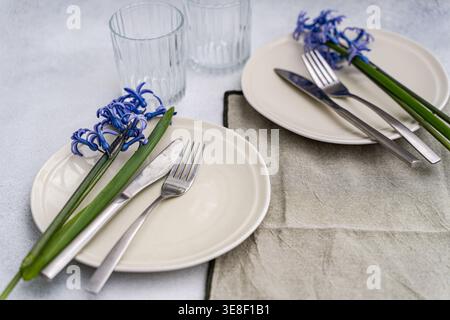Overhead view of two rustic spring place settings with fresh blue hyacinths on a table Stock Photo