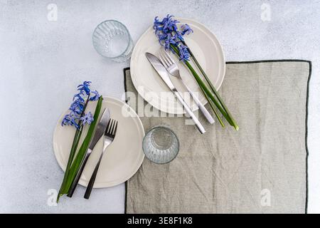 Overhead view of two rustic spring place settings with fresh blue hyacinths on a table Stock Photo