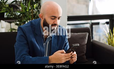 Businessman creating startup report on smartphone app, using online analytics and solving development problems in office. Startup consultant thinking about new business plan and solution. Stock Photo