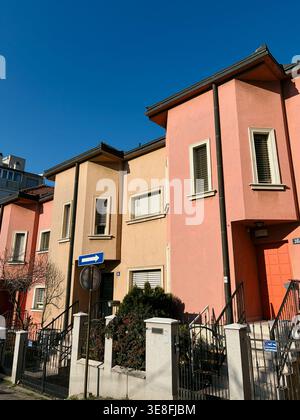 Modern pastel colored houses with clear blue sky in urban neighborhood. Concept of real estate, architecture and residential lifestyle. Stock Photo