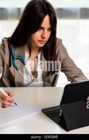 Female doctor consulting patient records using digital tablet Stock Photo