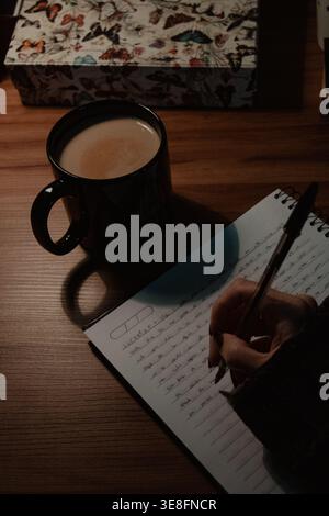 Hand Writing in Notebook with Coffee Stock Photo