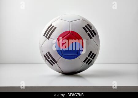 A soccer ball featuring the South Korean flag design, centered on a clean white background with soft lighting, highlighting its texture and geometric Stock Photo