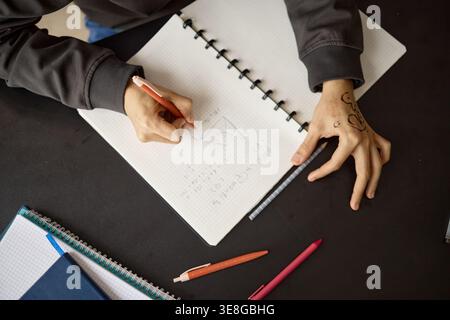 Teenager Writing Math Notes in Notebook for School Learning Stock Photo