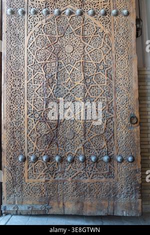 Intricately Carved Islamic Wooden Door with Geometric and Floral Patterns Stock Photo