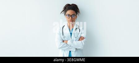 Doctor Standing With Arms Crossed in a Plain Setting During Daylight Hours Stock Photo