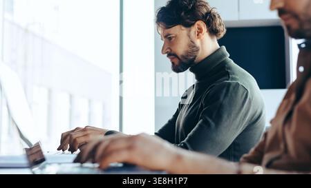 Two Men Working on Laptops in a Bright Office Space During Daytime Stock Photo