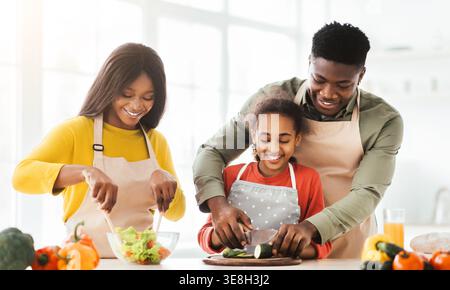 Family Cooking Together in Kitchen Preparing Salad and Vegetables Stock Photo