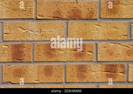 Macro shot of yellow and orange klinkier brick wall texture. Detailed background for architecture and construction industries. Stock Photo