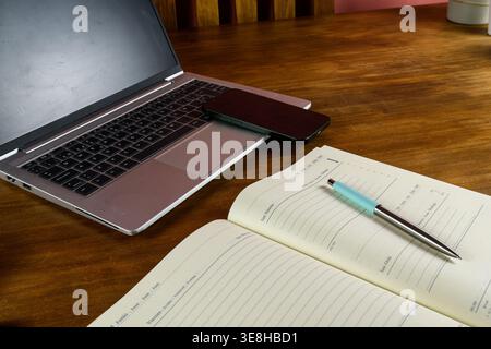 Smartphone placed on laptop keyboard, representing pause, multitasking and modern digital workflow. Stock Photo