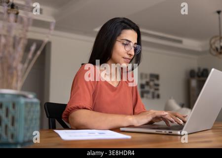 Woman working on laptop at wooden table at homeoffice Stock Photo