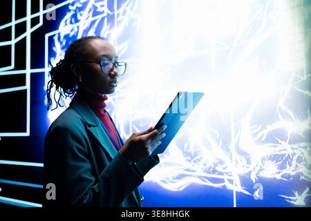 Software developer seeing autonomous AI agent writing complex code on digital videowall. Close up of system administrator tracking self generating artificial intelligence architecture on tablet Stock Photo
