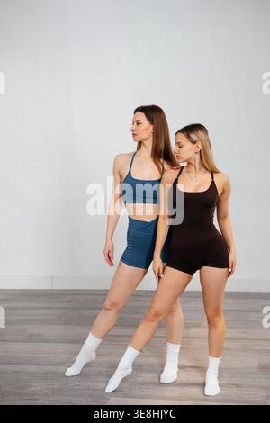 Women doing fitness workout together. Attractive women practicing stretching and strength exercises. Female models in healthy lifestyle and training c Stock Photo