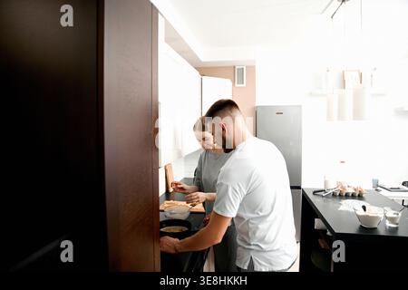Young couple preparing food together at home. Concept of love and daily routine. Stock Photo