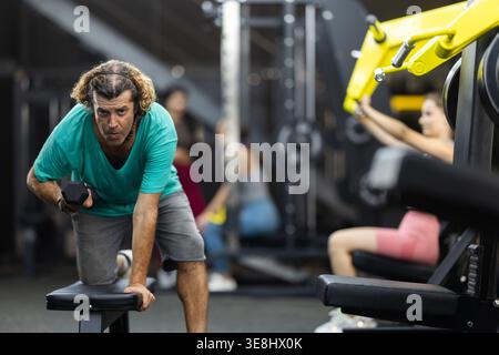 Man doing exercises with a dumbbell in the gym Stock Photo