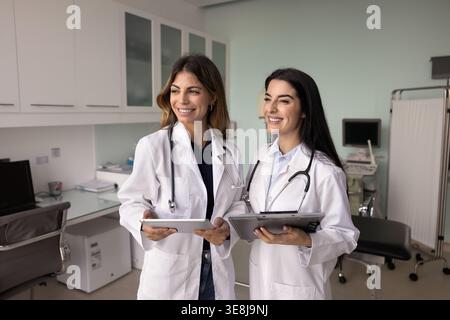 Two doctors in white coats engaged in medical team briefing Stock Photo