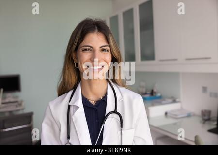 Head shot portrait of smiling Latin woman doctor Stock Photo
