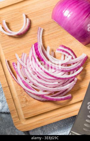 Organic Raw Cut Red Onions on a Cutting Board Stock Photo