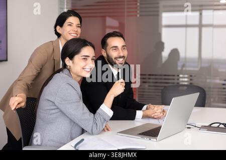 Multiethnic business team gather at conference table with laptop Stock Photo