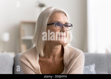Middle-aged woman looking into distance with thoughtful and reflective expression Stock Photo