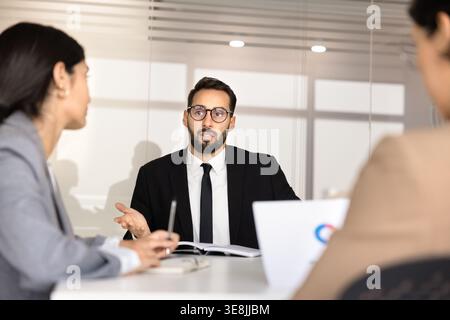 Executive man discussing business ideas with diverse team in meeting room Stock Photo