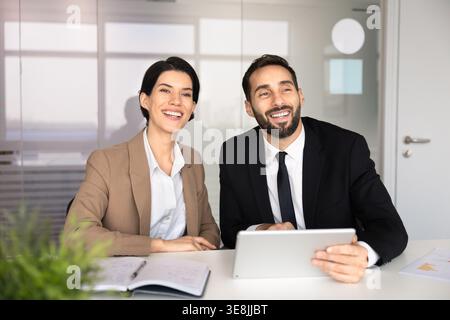 Professional team members, sitting at conference table with tablet Stock Photo