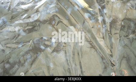 High contrast silver foil texture with dramatic highlights and heavy metallic wrinkles Stock Photo