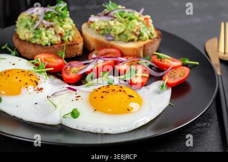 Clean eating breakfast with avocado toast, eggs and fresh vegetables Stock Photo