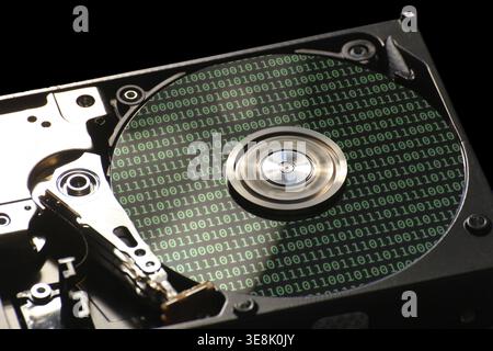 Hard disk on a black background with reflections on ones and zeros (binary code) Stock Photo