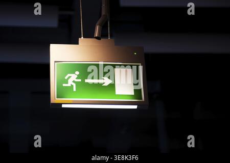 Emergency exit, illuminated green board Stock Photo