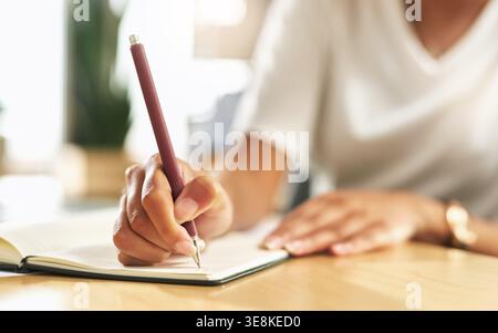Woman, hands and writing with pen on book in office for work schedule, reminder or planning. Female person, journalist or taking notes with notebook Stock Photo