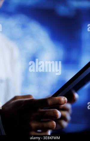 Programmer writes code on tablet to visualize artificial intelligence neural networks using augmented reality, close up. Qualified employee runs AI script for information processing Stock Photo