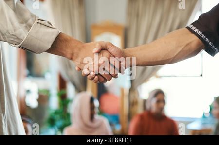 Greeting, shaking hands and Muslim men in home, religion and respect tradition for social gathering. Islamic, handshake and people with faith for Stock Photo