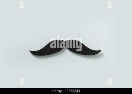 Black moustache isolated on blue background. Creative concept for Father Day. Moustache month and challenge. Mens Health Stock Photo