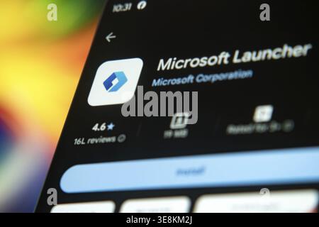 Dhaka, Bangladesh 26 Dec 2025:Smartphone featuring Microsoft Launcher app and earphones against a blue background Stock Photo