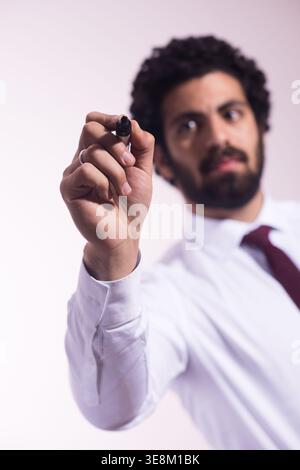 Businessman writing with marker during presentation or planning session in office setting Stock Photo
