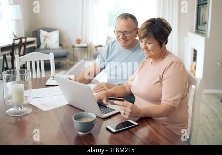 Credit card, laptop and couple in home, payment or internet for investment. Savings, mature man or woman in lounge, pc or ecommerce with online Stock Photo