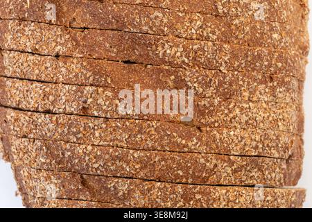 Top view of artisanal whole wheat, rye, multi-grain bread slices with bran flakes on white background. Close-up Stock Photo