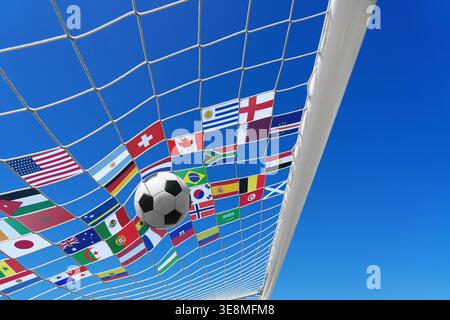 Soccer ball in soccer goal net in a big stadium isolated on blue sky with all the flags of the participating countries. soccer net. Stock Photo