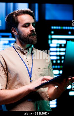 Expert in server room with advanced data storage infrastructure storing massive datasets, supporting intensive operations requiring IT equipment to run at high power densities Stock Photo