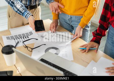 Teamwork brainstorm. Unrecognizable diverse colleagues working together discuss financial statistics. Group of people in creative office discussing business, focus on hands close up. Professional team Stock Photo