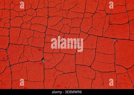 Red grungy background. Retro style texture of peeling paint. Weathered cracked paint grunge background surface. Stock Photo