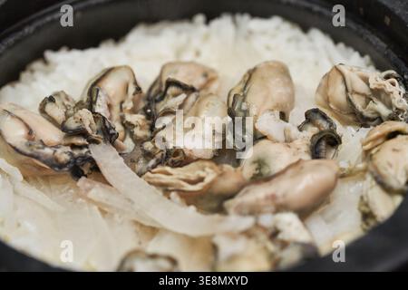 Korean Gul Mu-bap features fluffy rice cooked with plump oysters and sliced radish. These photos capture the comforting, savory essence of winter. Stock Photo