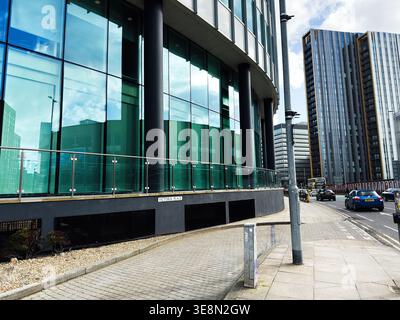 Manchester, UK - February 22, 2026: Curved glass office building on Victoria Place beside a busy street in Manchester, UK. Stock Photo