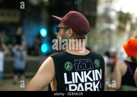 Plovdiv, Bulgaria – July 26, 2025: A bearded man wearing sunglasses, a cap, a large ear gauge, and a printed sleeveless shirt stands outdoors in a pub Stock Photo