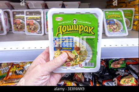Samara, Russia - October 26, 2025: Chinese noodles Doshirak in a plastic boxes in the hand. Instant noodles. Selective focus Stock Photo