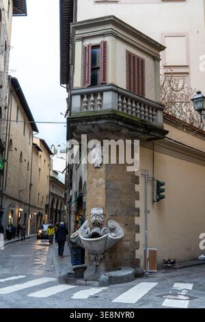 A charming street scene in Florence, Italy, featuring an ornate fountain and a detailed balcony on an old building Stock Photo
